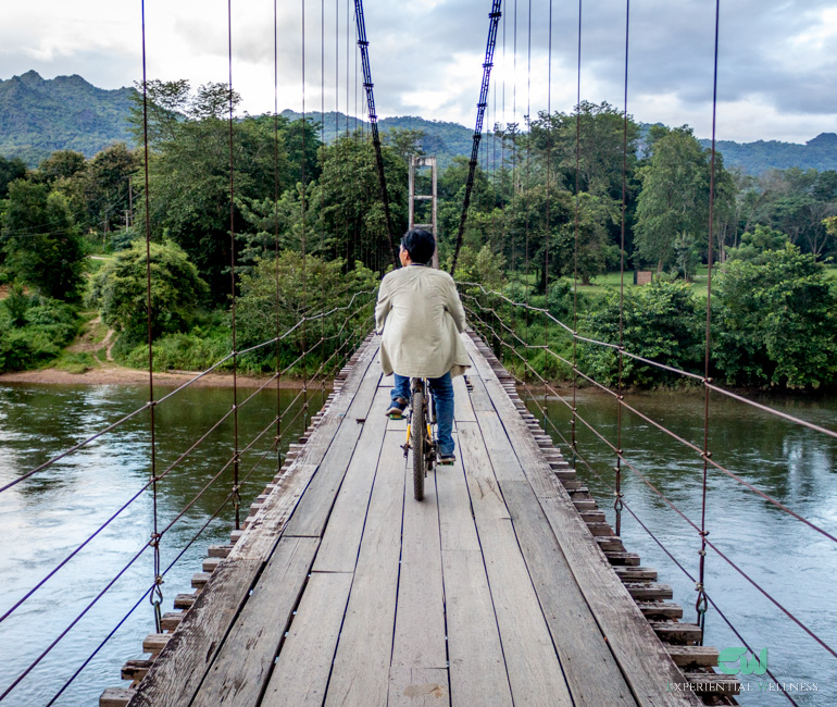 A man bikes over the Hanging Bridge over the River Kwai