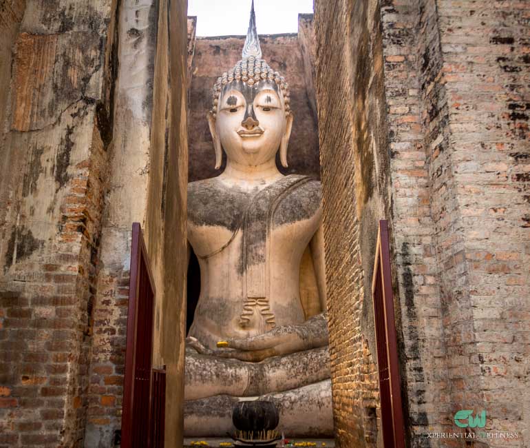 A Buddha image seated in a small brick Mandapa. This is the main highlight of the Sukhothai Historical Park